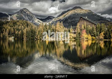 Giorno nuvoloso scuro in montagna. Riflesso delle cime sulla superficie d'acqua del tarn Strbske pleso nella montagna alta Tatra in Slovacchia Foto Stock
