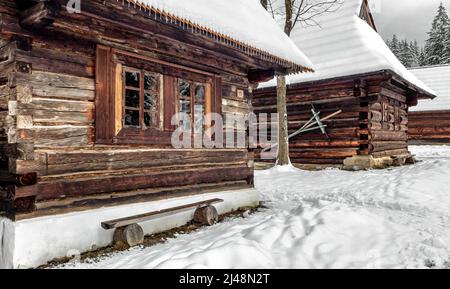 Cottage rurale in legno nel villaggio nevoso in inverno. Museo all'aperto a Zuberec, Slovacchia Foto Stock