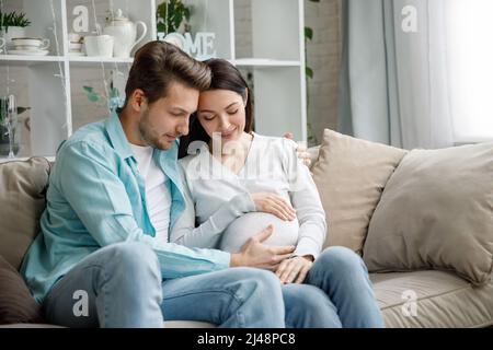 Coppia in attesa di un bambino, mentre il marito carezza il ventre della donna incinta. Foto Stock