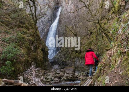 Persone che camminano lungo un sentiero scivoloso che porta alla Taglia di Gray Mare, una delle cascate più impressionanti in Scozia, Regno Unito Foto Stock