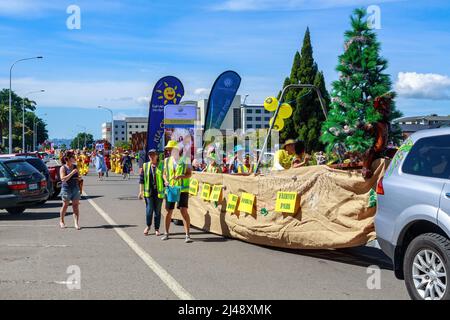 Sfilata di Natale a Rotorua, Nuova Zelanda. Asilo bambini che cavalcano in una waka (canoa) con un albero di Natale Foto Stock