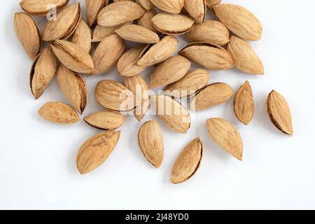 vista dall'alto dei drupi di mandorle non pelati isolati su sfondo bianco, concetto di cibo sano Foto Stock