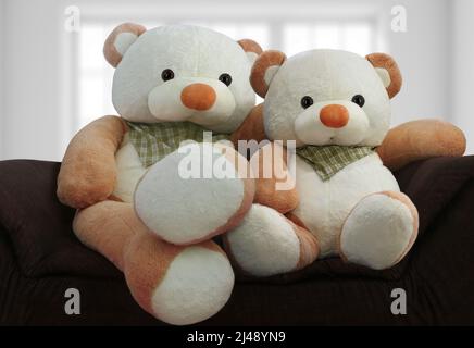 Big TOY Bears seduta insieme sul divano come padre e figlio genitori concetto. Foto Stock