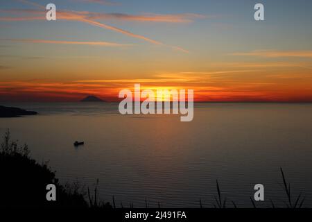 Tramonto sul Mar Tirreno con l'isola vulcanica di Stromboli all'orizzonte Foto Stock