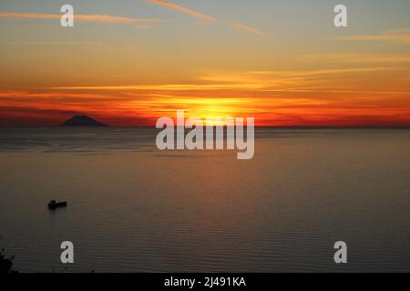 Tramonto sul Mar Tirreno con l'isola vulcanica di Stromboli all'orizzonte Foto Stock