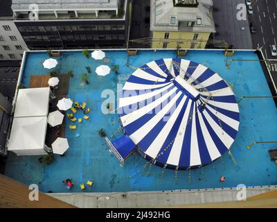 Linz, Austria - 06 luglio 2013: Vista aerea di una tenda circense a strisce e posti a sedere su una zona del tetto Foto Stock