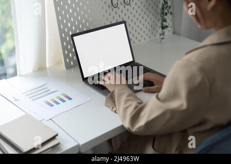 Giovane uomo che lavora sul suo laptop con schermo vuoto spazio copia per il vostro messaggio di testo pubblicitario in ufficio, vista posteriore di uomo d'affari mani occupate utilizzando Foto Stock