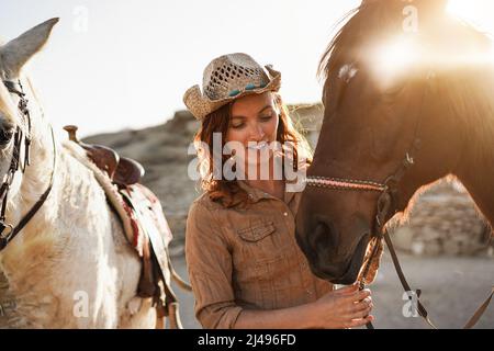 Giovane donna contadina che gioca con il suo cavallo al ranch fattoria - Focus on Face Foto Stock