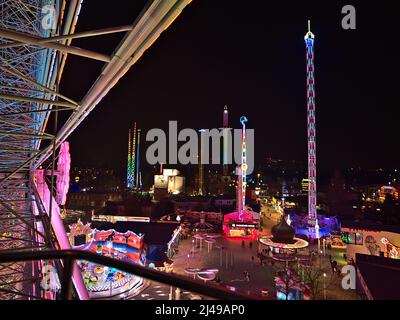 Splendida vista aerea sul parco divertimenti Wurstelprater di Vienna, Austria di notte con giostre illuminate viste dalla ruota panoramica Blumenrad. Foto Stock
