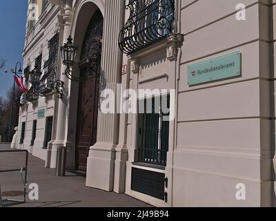 Vista dell'ingresso di Bundeskanzleramt (BKA), Cancelleria d'Austria, nel centro di Vienna in edificio storico con bandiere e cartello sul muro. Foto Stock