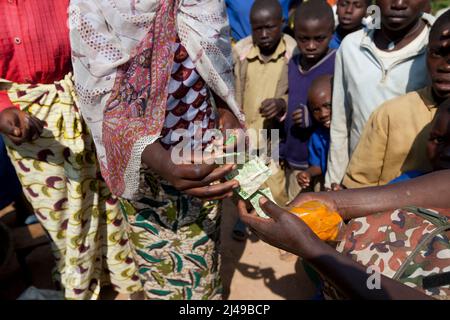 Zainab Nyirazirwanda, 45 anni, vedova il cui marito morì nel 1994. Ha due figli, Shadia Nzayisenga, figlia, 20 e figlio Issa Tuzimana, 17 e nipote, Maniraguha, 2. Prima del programma la sua agricoltura ha prodotto molto poco. Ora dai proventi della sua agricoltura ha comprato una mucca, polli, capre. Ha comprato terra per coltivare mais e vende sale e olio di palma nel mercato. Ha comprato un telefono cellulare e invia suo figlio alla scuola secondaria. Fotografia di Mike Goldwater Foto Stock