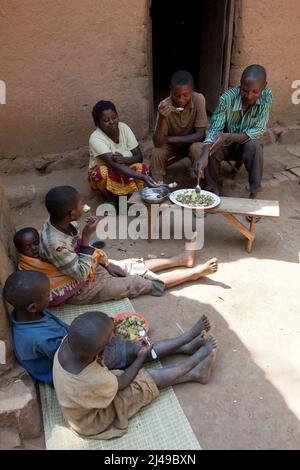 Triphonie Bosenibo, 36 anni, marito Daniel Bwanakweri, 45 anni, e ha 7 figli. Il 5 presente Jean Didier Dufatanye, 18, Sandrine Umuruta Satte, 12, Jean D'Amour Niyonkwizera, 9, Emmanuel Niyonshuti, 7, e Valentine Umutesi, 18 mesi. La famiglia mangiava una volta al giorno e spesso va affamata, lavorando un lavoratore salariale sulla terra degli altri. Ora mangiano due o tre volte al giorno, compresi i vegitable. Daniel dice che non pensa mai di lavorare per altre persone ora. Fotografia di Mike Goldwater Foto Stock