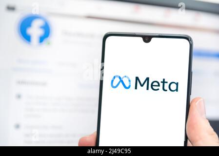 Wroclaw, Polonia - Apr 01, 2022: Facebook cambia il nome della sua azienda in Meta. Meta su uno smartphone e logo Facebook sullo sfondo Foto Stock