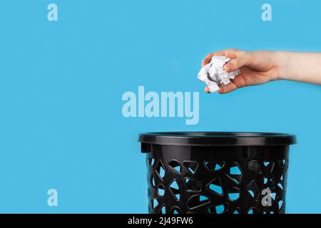 I segnalatori luminosi bianchi di carta sgualciti vengono gettati nel cestino. Per spazio di copia per i designer su sfondo blu Foto Stock