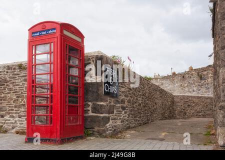 Clichés della Gran Bretagna: Cabina telefonica rossa, mura del castello, segno di fish and chips, cielo stellato. Foto Stock