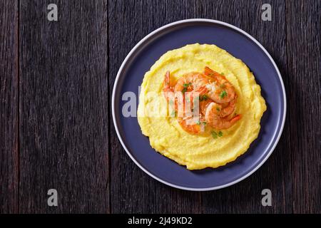 Polenta e schie fritte, piatto veneziano, polenta con gamberi fritti su piatto su tavola di legno scuro, vista orizzontale dall'alto, piatto, spazio libero Foto Stock