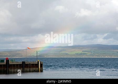 Rainbow brilla attraverso il molo a Coillemore Point Loch Ranza Isola di Arran Nord Ayrshire Scozia Foto Stock