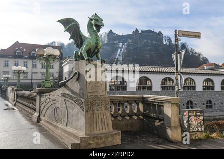 Lubiana: Ponte del drago, con il castello sullo sfondo. Slovenia Foto Stock