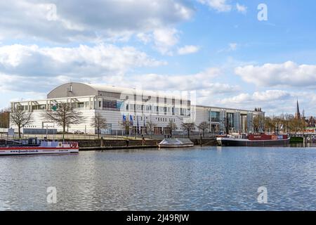 Lubeck, Germania, 11 aprile 2022: Sala musica e congressi chiamata Muk a Lubeck sul fiume trave, edificio moderno di Meinhard von Gerkan, cielo blu wit Foto Stock