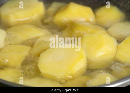 Primo piano delle patate che vengono cotte in acqua bollente in una pentola. Foto Stock