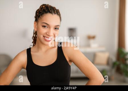 Felice African American Woman con capelli intrecciati in posa a casa Foto Stock