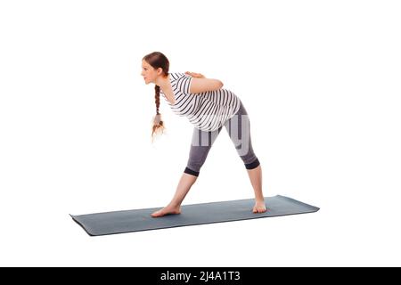 Donna incinta che fa yoga asana parsvottanasana Foto Stock