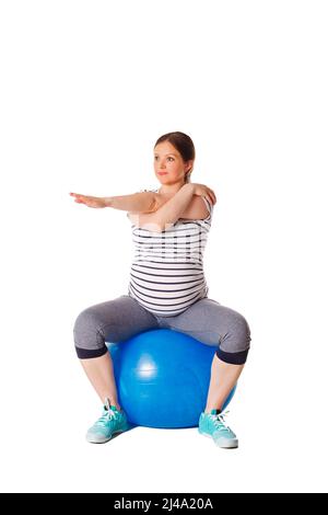 Donna incinta che fa le esercitazioni con la sfera di esercitazione Foto Stock