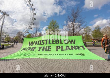 Londra, Regno Unito. 13 aprile 2022. Un grande banner di protesta verde con la scritta "WHISTLEBLOW FOR THE PLANET" è esposto sulla South Bank di Londra, con il London Eye visibile sullo sfondo. I manifestanti della ribellione di Extinction bloccano gli ingressi al quartier generale della Shell UK London sulla Southbank. Penelope Barritt/Alamy Live News Foto Stock
