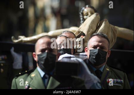 Malaga, Spagna, 13/04/2022, i membri della brigata paracadutista spagnola dell'esercito spagnolo sono visti portare con sé una statua del Cristo de Animas y Ciegos mentre si esibiscono in una sfilata durante il mercoledì Santo, in occasione delle celebrazioni della settimana Santa. Dopo due anni senza la settimana Santa a causa della pandemia del coronavirus, migliaia di fedeli attendono di vedere le processioni che portano le statue di Cristo e della Vergine Maria per le strade come parte della settimana Santa tradizionale. Credit: SOPA Images Limited/Alamy Live News Foto Stock