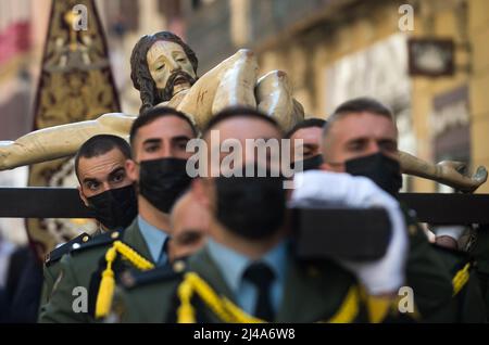 Malaga, Spagna, 13/04/2022, i membri della brigata paracadutista spagnola dell'esercito spagnolo sono visti portare con sé una statua del Cristo de Animas y Ciegos mentre si esibiscono in una sfilata durante il mercoledì Santo, in occasione delle celebrazioni della settimana Santa. Dopo due anni senza la settimana Santa a causa della pandemia del coronavirus, migliaia di fedeli attendono di vedere le processioni che portano le statue di Cristo e della Vergine Maria per le strade come parte della settimana Santa tradizionale. Credit: SOPA Images Limited/Alamy Live News Foto Stock