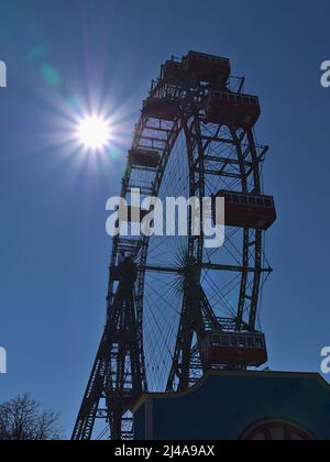 Bella vista della popolare ruota panoramica (Riesenrad) al parco a tema Wurstelprater a Vienna, Austria con le sagome delle gondole in giorno di sole. Foto Stock