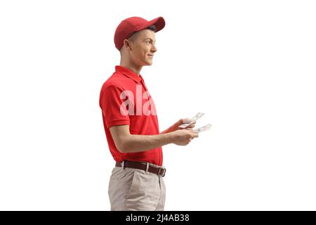 Colpo di profilo di un cassiere maschio in un uniforme denaro di tenuta isolato su sfondo bianco Foto Stock