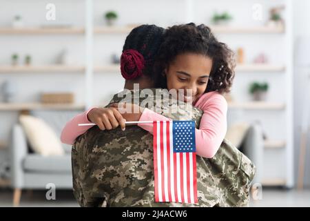 Ragazza felice con la bandiera degli Stati Uniti che abbraccia la mamma Foto Stock