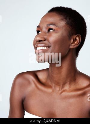 Tutto su di lei dice bello. Studio girato di una bella giovane donna che guarda pensieroso su uno sfondo grigio. Foto Stock