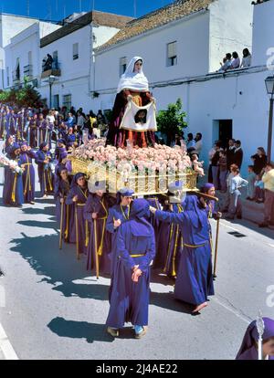 ARCOS DE LA FRONTERA,SPAGNA-APRILE,21 2000: Un gruppo di portatrici femminili che trasportano un galleggiante religioso (noto come Tronos) nelle processioni tenute per partecipare Foto Stock