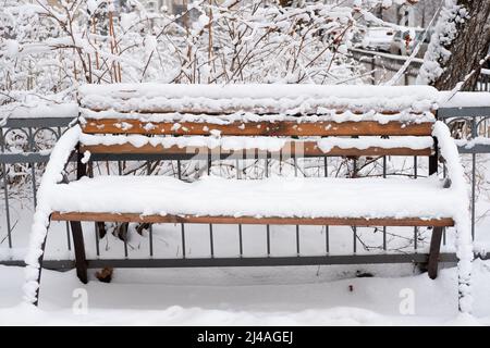 panca di strada nella neve. Nevicate pesanti. Conseguenze della nevicata. Strade senza rimozione della neve Foto Stock