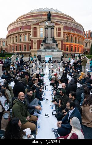 Le persone si riuniscono presso il più grande Iftar aperto del Regno Unito organizzato dal Ramadan Tent Project, sui gradini della Royal Albert Hall, Londra, che riunisce le persone di tutte le comunità per condividere un Iftar (pasto serale) per rompere velocemente durante il mese santo islamico del Ramadan. Data foto: Mercoledì 13 aprile 2022. Foto Stock