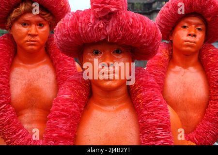 Un giovane devotee indù con il suo corpo dipinto di rosso prende parte durante una processione che tiene spade come parte dell'annuale Lal Kach (vetro rosso) fes Foto Stock