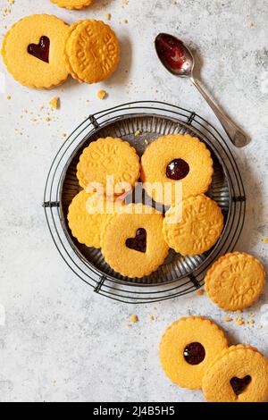 Un piatto di biscotti sandwich aromatizzati alla crema su una rastrelliera metallica. Foto Stock