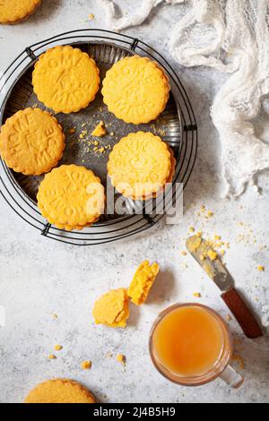 Biscotti sandwich in stile crema alla crema e una tazza di tè. Foto Stock