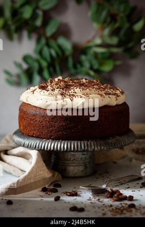 Una torta al caffè con panna montata infusa con liquore alla panna irlandese. Il cioccolato grattugiato fornisce la guarnitura finale. Foto Stock