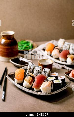 Panini con sushi per due. Sushi tradizionale giapponese e panini con salmone fresco, tonno, anguilla e gamberi sul riso. Servire su piatti con salsa di soia A. Foto Stock