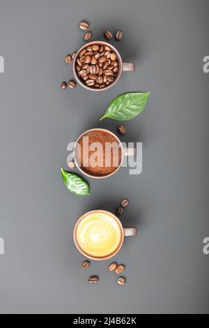 Composizione del caffè con tre tazze di caffè su sfondo scuro, a struttura piatta Foto Stock