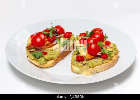 Sano panino vegano aperto con purè di avocado, zucchine, pomodori ciliegini, formaggio sul pane di mais. Cibo sano, concetto di cibo vegetariano Foto Stock