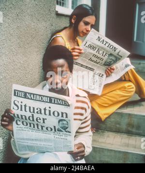 Due donne leggono notizie del tentativo di colpo di stato militare in Kenya 1982 Foto Stock