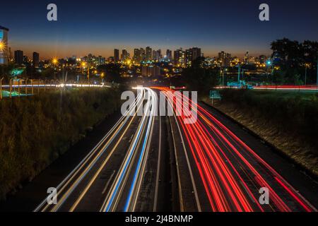 Marília, SP, BRASIL, 19.03.2019 – Rastro de luz provocado pelo trânsito de Veículos na SP-294 - Rodovia Comandante João Ribeiro Barros com prédios do Foto Stock