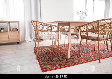 Interno di sala da pranzo luminosa con tavolo e tappeto vintage Foto Stock