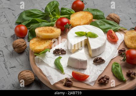 Formaggio Camembert, basilico, pomodori ciliegini, crostini di baguette. Vista dall'alto, con spazio vuoto per l'iscrizione Foto Stock
