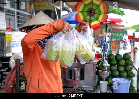 Ho Chi Minh City, Vietnam, 13 aprile 2022: Donna che spreme il succo di canna da zucchero. Popolare Street drink a ho Chi Minh City, Vietnam Foto Stock