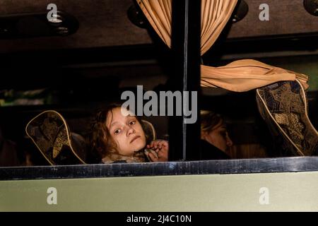 Cracovia, Polonia. 11th Apr 2022. Una ragazza guarda attraverso una finestra di pullman mentre è sulla sua strada di ritorno in Ucraina trasportato da un'attività di volontariato - Abdar Travel Agency come parte del loro sforzo umanitario per l'Ucraina colpita dalla guerra. Mentre la Federazione russa ha invaso l'Ucraina, il conflitto dovrebbe costringere fino a 5 milioni di ucraini a fuggire dal paese e a creare un gran numero di rifugiati interni. Gli ucraini hanno un grave bisogno di forniture mediche, cibo, vestiti e altro ancora. (Foto di Dominika Zarzycka/SOPA Images/Sipa USA) Credit: Sipa USA/Alamy Live News Foto Stock